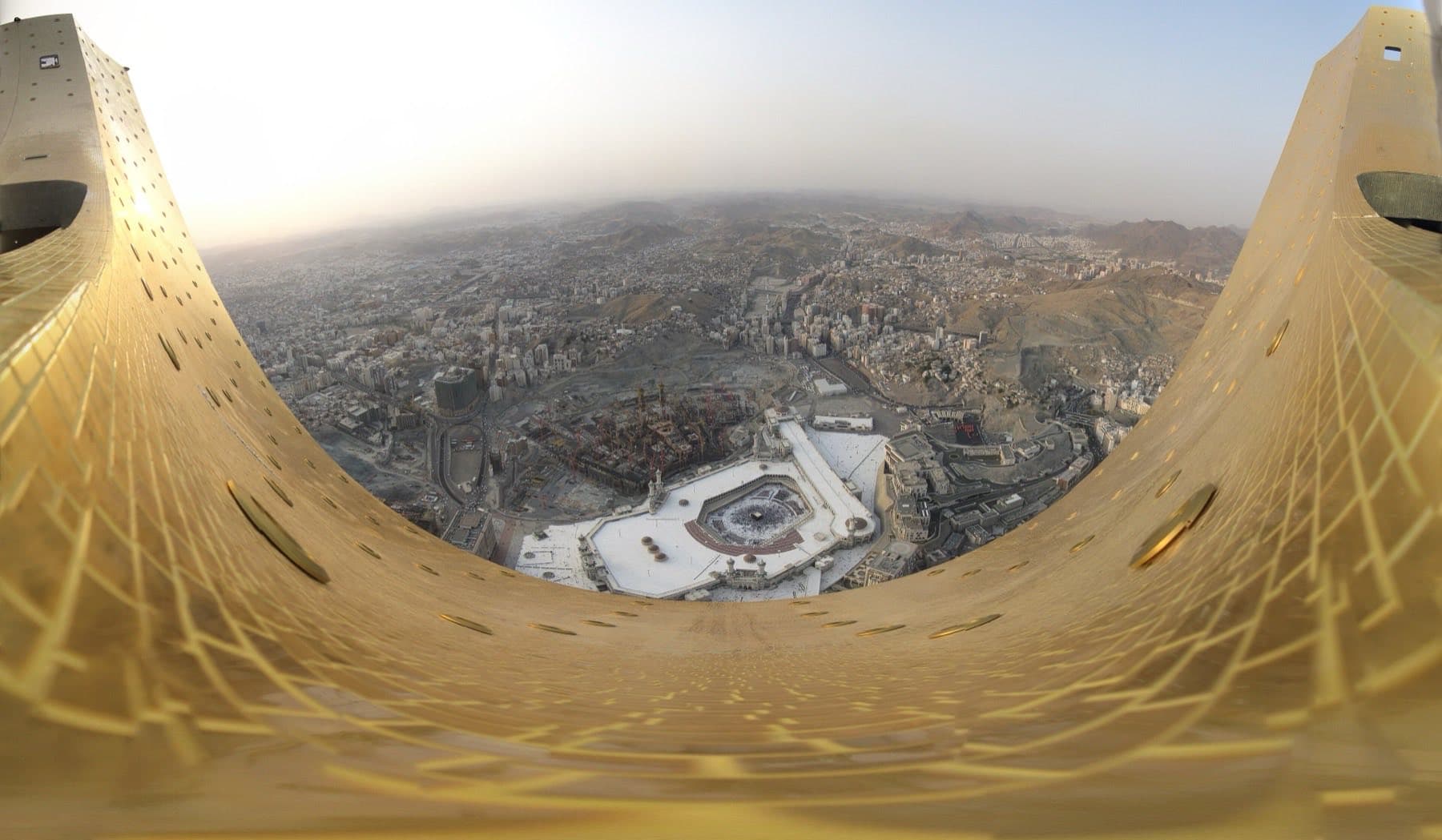 Panorama of Makkah at night with the Haram and the Clock Tower lit against the hills.